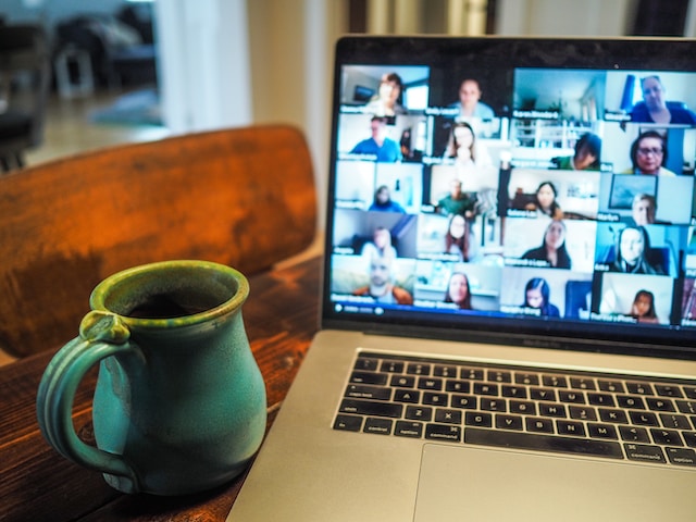 Image of a videoconference on a laptop with a mug.