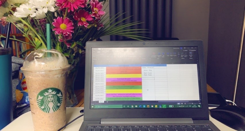 A picture of a Frappuccino, a computer and some flowers 
