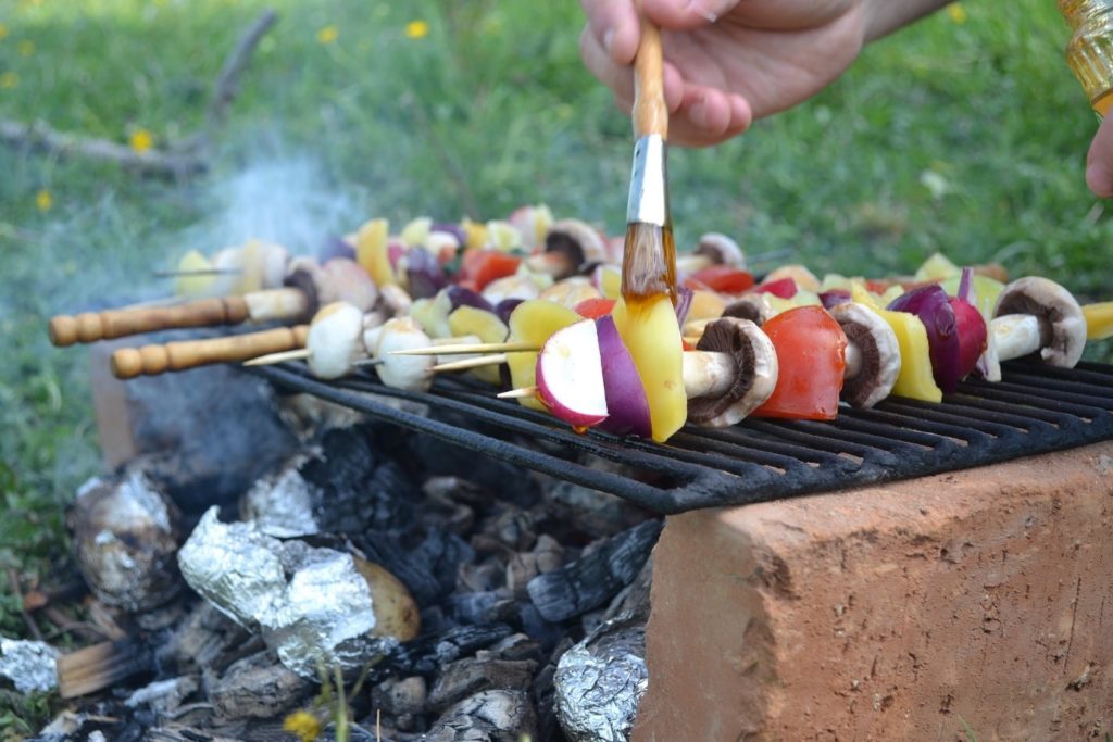 A photograph of a barbeque and vegetable skewers. 