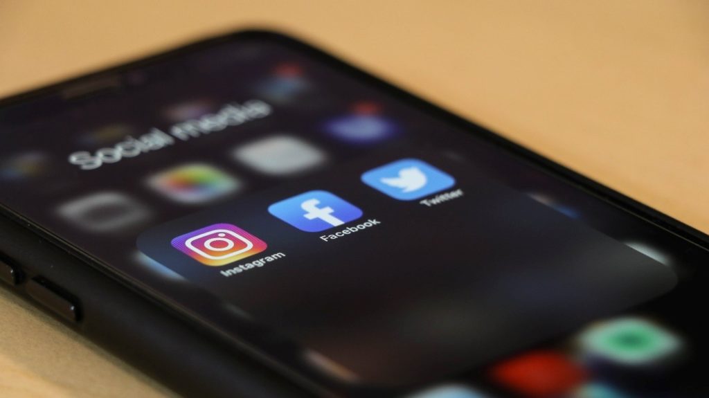 Image of an iPhone screen displaying Instagram, Facebook and Twitter apps.