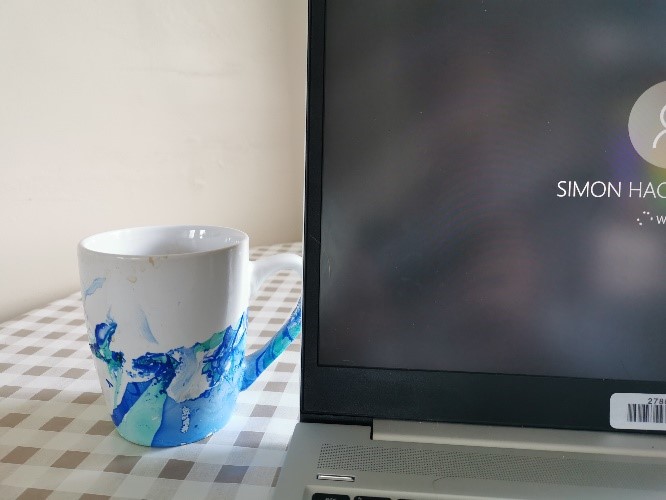 A cup of tea next to a laptop