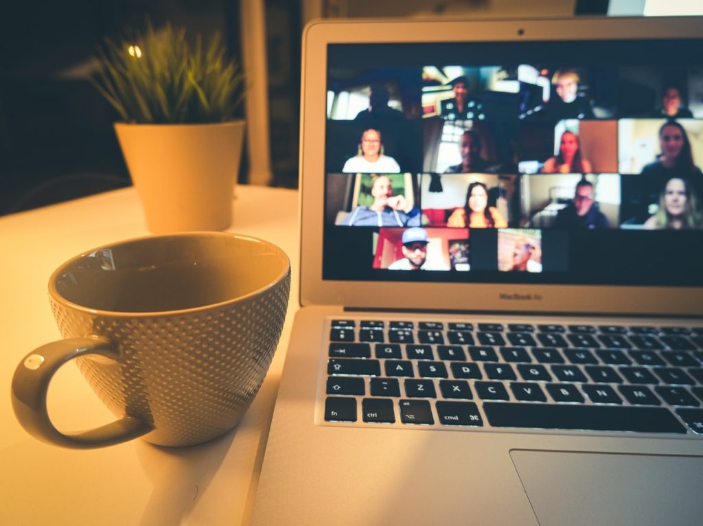 Photograph of computer with people on an online video call. 