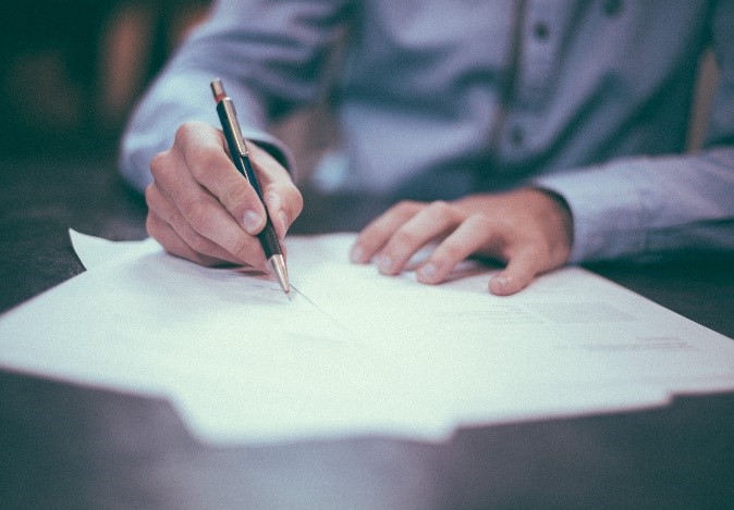 Photograph of Student writing on a piece of paper