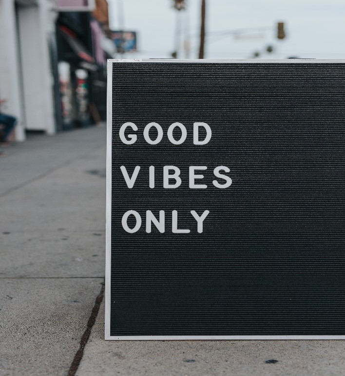 A picture containing text saying good vibes only on an outdoor sign.