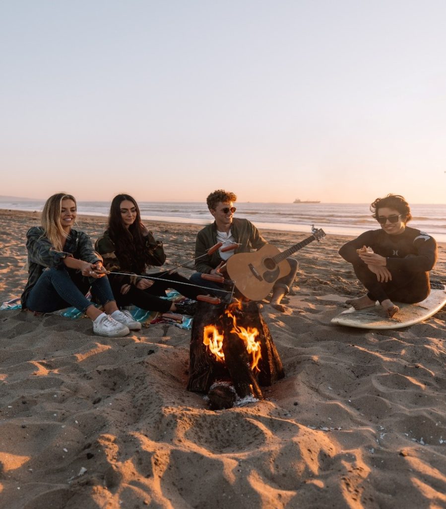 Photograph of people sitting around a campfire