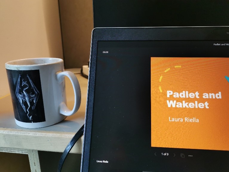 A cup of tea on a desk next to a laptop, viewing the Padlet and Wakelet training session.
