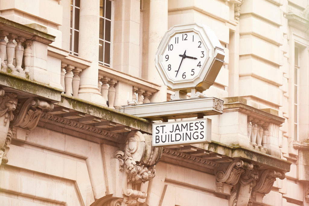 The large clock above the main door of the neo-classical entrance to the St James building.