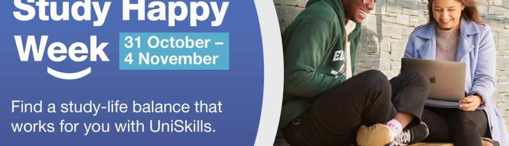 Two students sat on a bench smiling