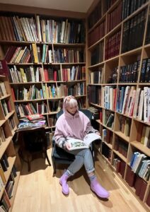 Photograph of Julie Nolan reading in a library.