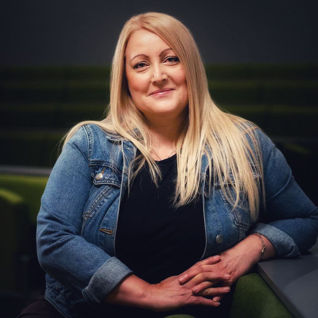 Student Advisor Michelle Hopwood. Michelle has long blond hair and wears a denim jacket with a black top.