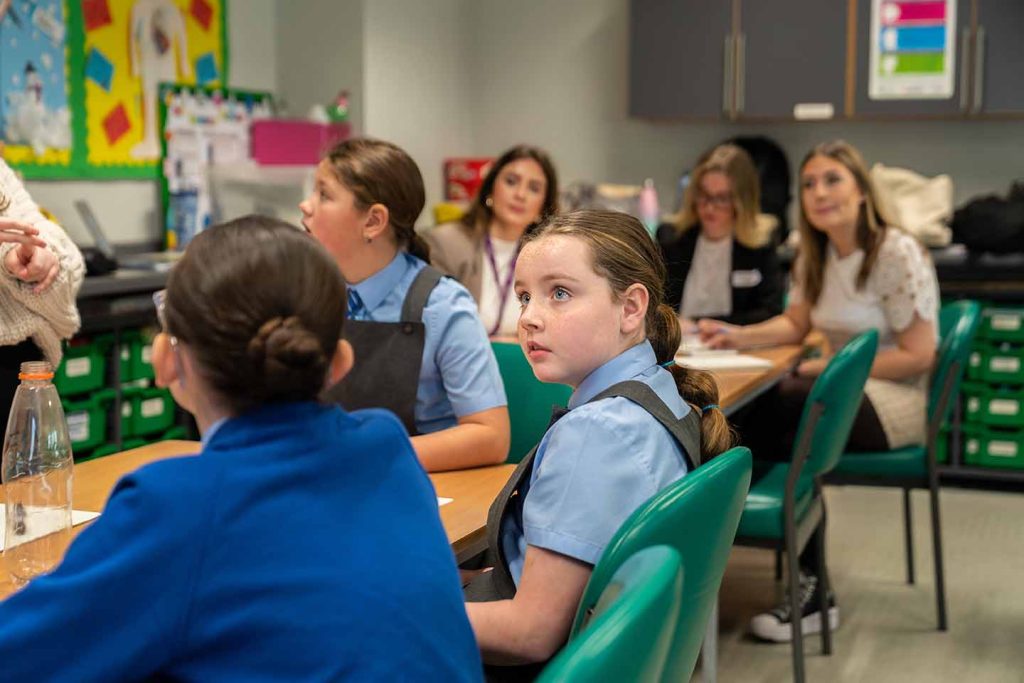Primary children in a classroom listening to their teacher