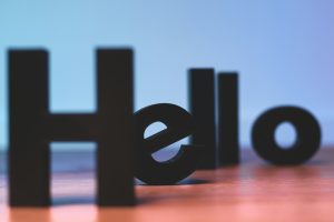 Black letter blocks on a table surface. They spell the word, "Hello".