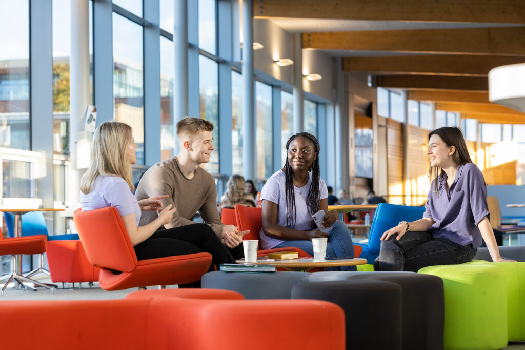 A group of students sitting in the Hub socialising.