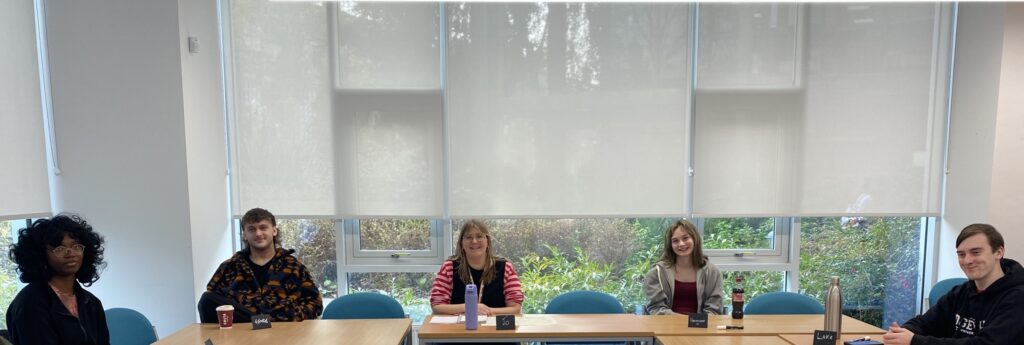 A group of students sitting around a table attending panel