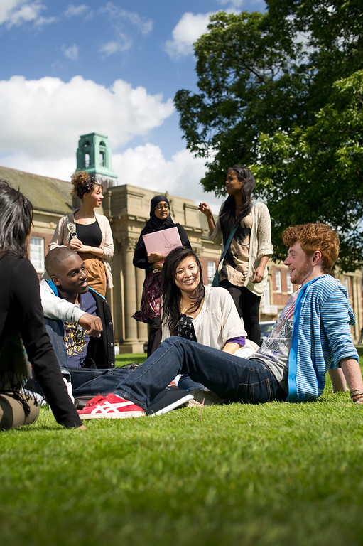 Students sitting in a circle chatting outside main building